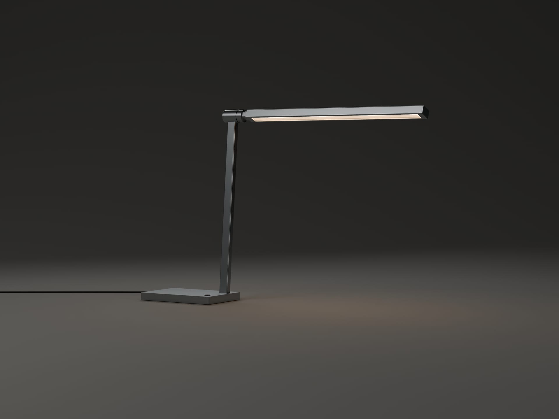 L01 in a dark room, switched on: the head glows warm white and a soft pool of light falls across the surface beside the base.