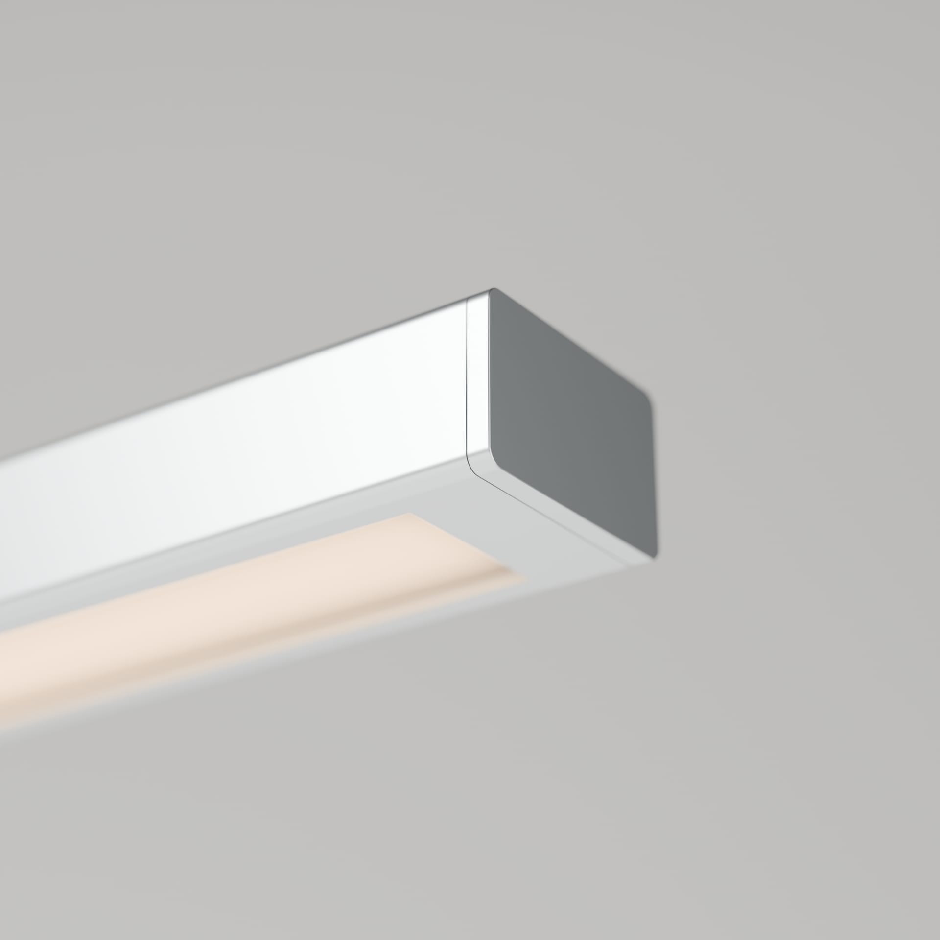Close view of the free end of the light head: a square aluminum end cap and a recessed opal diffuser glowing warm white along the underside.