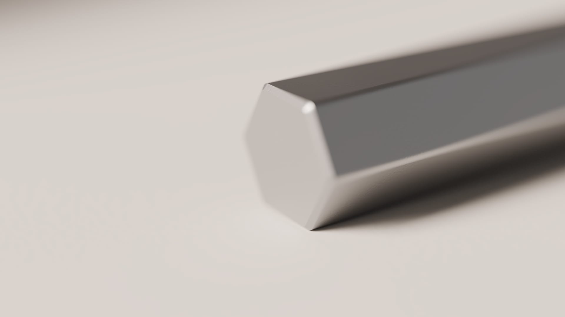 End-on view of a hex wrench: a six-sided working face with a small chamfered edge, in soft focus along the arm.